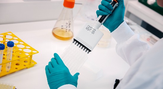 Multiple labeled vials containing vaccine samples or research materials, partially submerged in crushed ice, to ensure cool storage in a laboratory setting